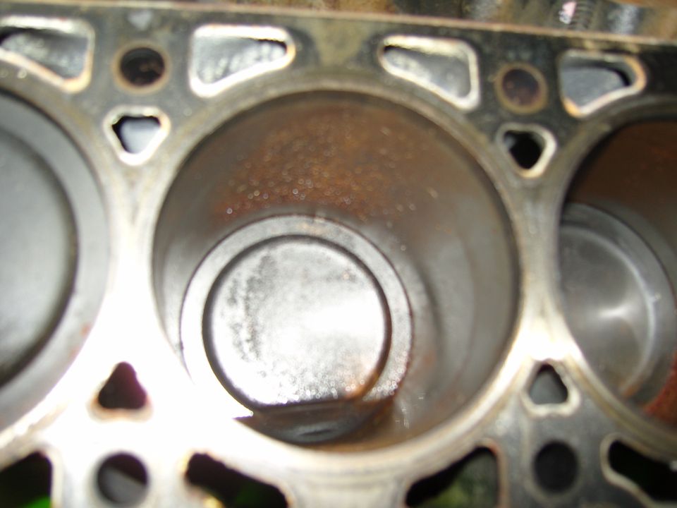 Close-up of an engine cylinder bore and piston in the block deck