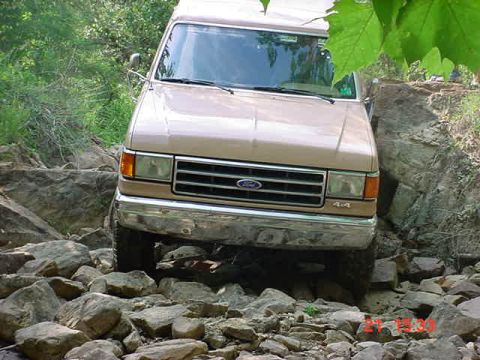 1989 Ford Bronco - This Ford Bronco is shown navigating a challenging rocky terrain, with its front end prominently displayed.