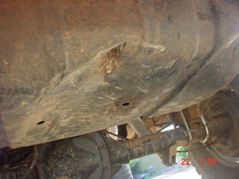 1989 Ford Bronco - The underside of a vehicle displays significant rust and wear, with visible suspension components.