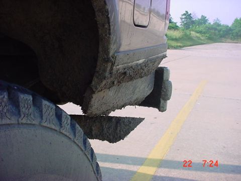 1989 Ford Bronco - Vehicle shows significant mud accumulation on its fender, tire, and lower body panels.