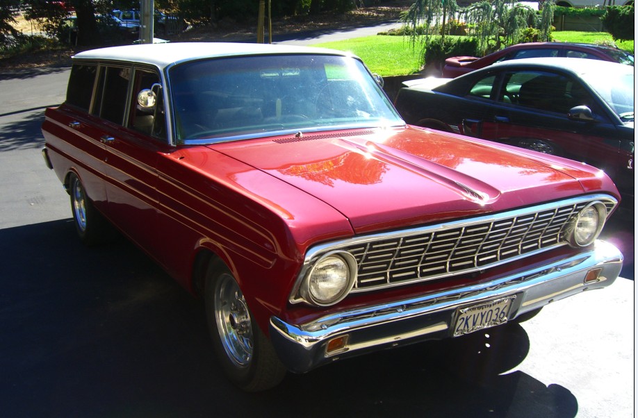Red and white 1964 Ford Falcon station wagon, 3/4 front view in a driveway