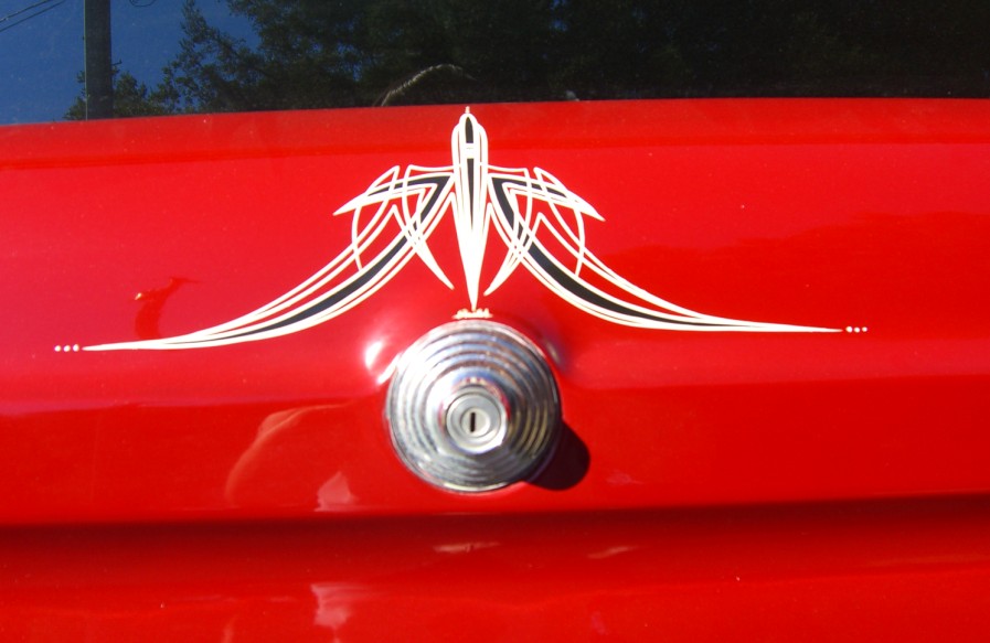 Red body panel with white-and-black pinstriping and a chrome lock handle