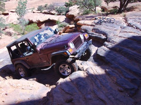 1995 Ford Bronco - Jeep Wrangler TJ navigating a rocky off-road trail.