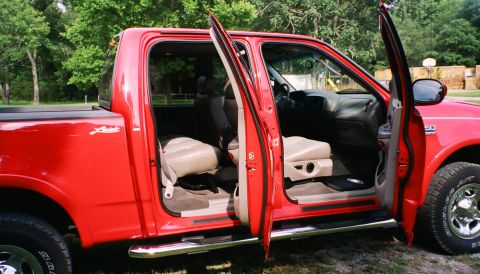 2007 Ford Mustang - The interior of a red pickup truck is visible with both front doors open.