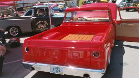 2007 Ford Mustang - A red pickup truck is parked next to a grey truck with 'Golden West Towing Equipment' on its door.