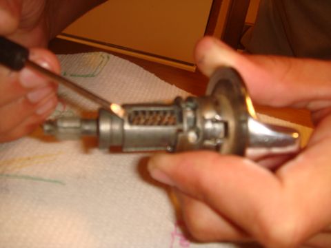 1992 Ford Bronco - Close-up of an ignition lock cylinder with a tool being used to manipulate its internal components.