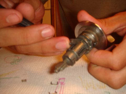 1992 Ford Bronco - Close-up of a person's hands manipulating a vehicle's ignition lock cylinder.