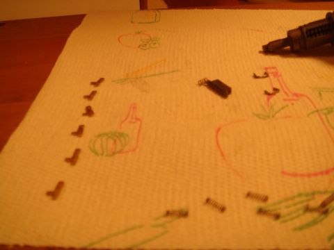 1992 Ford Bronco - Small metal parts and crayon drawings of a bottle and fruit are laid out on a paper towel.