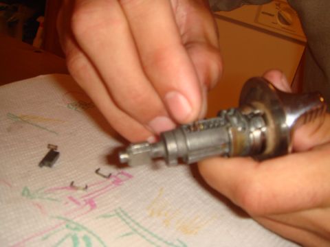 1992 Ford Bronco - Disassembled ignition lock cylinder with pins and tumblers laid out on a paper towel.