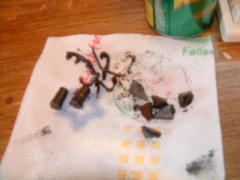 1988 Ford F-150 - Debris from a broken engine part lies on a paper towel next to a can.
