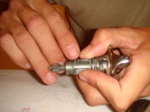 1992 Ford Bronco - Hands manipulate an ignition lock cylinder, likely for a rekeying process.