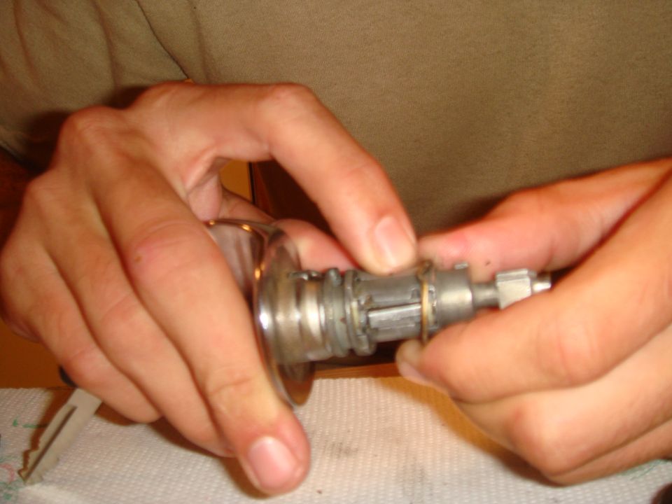 Hands holding a car ignition lock cylinder with a key inserted