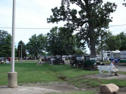 1909 Ford Model T - A gathering of antique cars, likely from the early 20th century, are displayed on a grassy field.