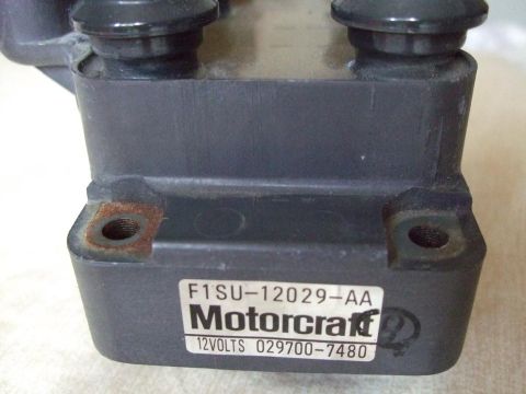 1992 Ford Probe - Close-up of a Motorcraft ignition coil, part number F1SU-12029-AA, with visible rust on its mounting holes.