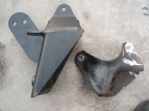 1987 Ford Bronco - Two metal brackets are shown on a concrete surface, with visible wear on the smaller part.