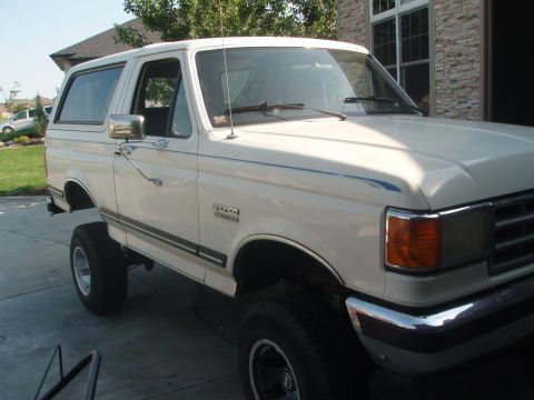 1987 Ford Bronco - This 1987 Ford Bronco features a lifted suspension and distinctive blue pinstripes along its side.