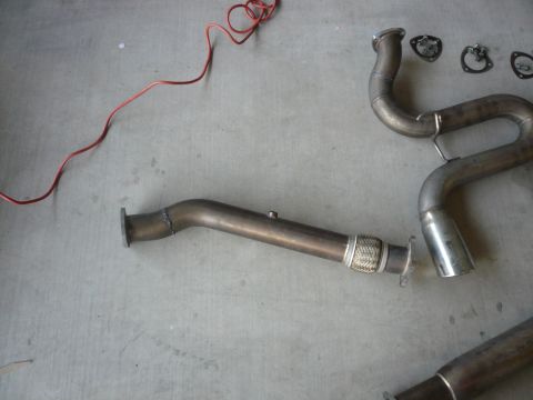 1996 Ford Probe - Various exhaust system components, including pipes and gaskets, are laid out on a concrete surface.