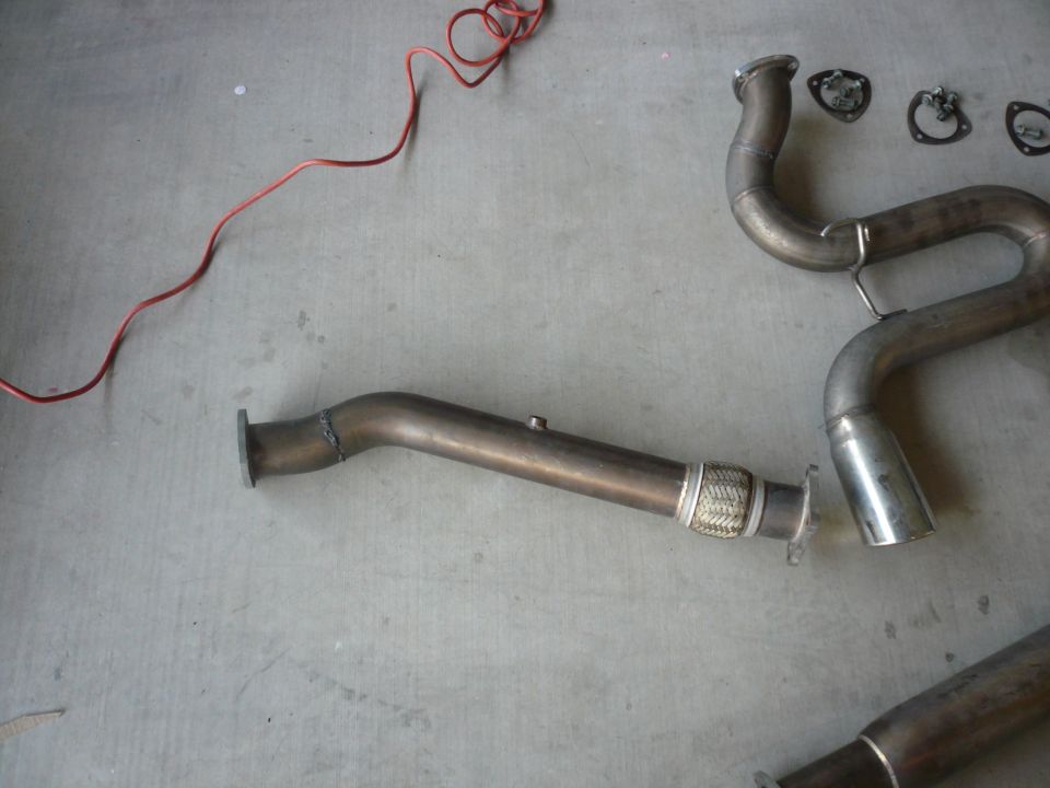 Exhaust system pipes and gaskets on a concrete floor