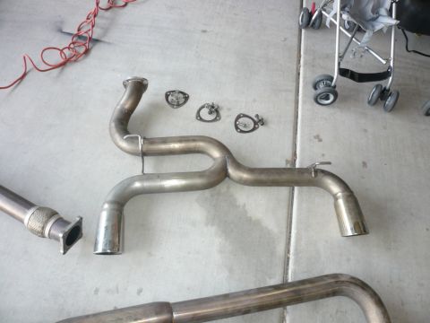 1996 Ford Probe - Exhaust system part with flex joint and gaskets laid out on a concrete surface.