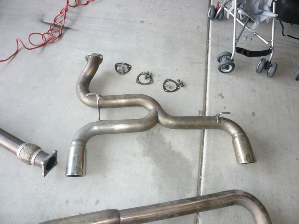 Exhaust system pipe with flex joint and gaskets on concrete floor