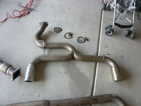 1996 Ford Probe - Several exhaust system components, including pipes and gaskets, are laid out on a concrete surface.