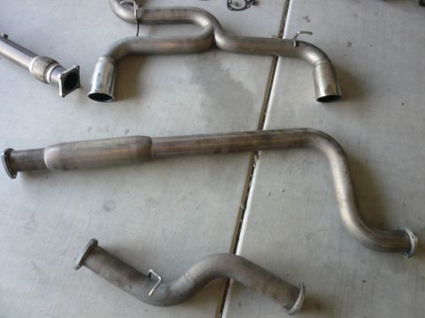 1996 Ford Probe - Multiple exhaust system components are arranged on a concrete surface.