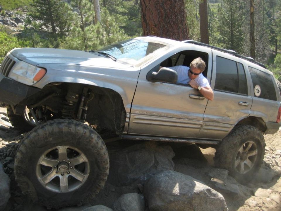 Silver 1999 Jeep Grand Cherokee on rocks