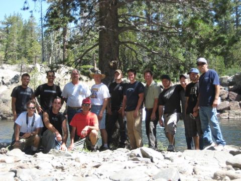 1999 Jeep Grand Cherokee - A group of men gathered by a riverbank, with trees and rocks in the background.