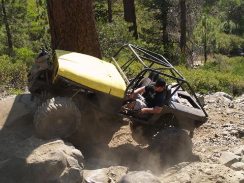 1999 Jeep Grand Cherokee - Two custom off-road vehicles are shown navigating a difficult rocky terrain.