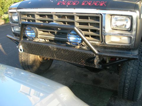 1985 Ford Bronco - Modified Ford truck front end with custom bumper and "MUDD DUCK" text on hood. Likely an early 1980s model.