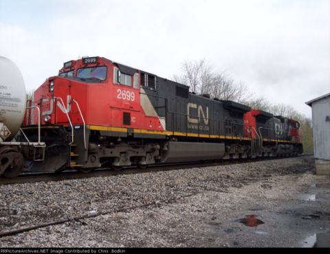 1967 Ford Mustang - A red and black CN train locomotive numbered 2699 is visible alongside a white tank car and another locomotive.