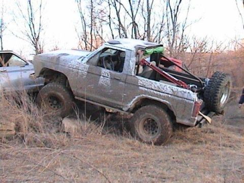 1987 Ford Bronco II - Modified 1987 Ford Bronco II with roll cage is stuck in the mud during an off-road excursion.