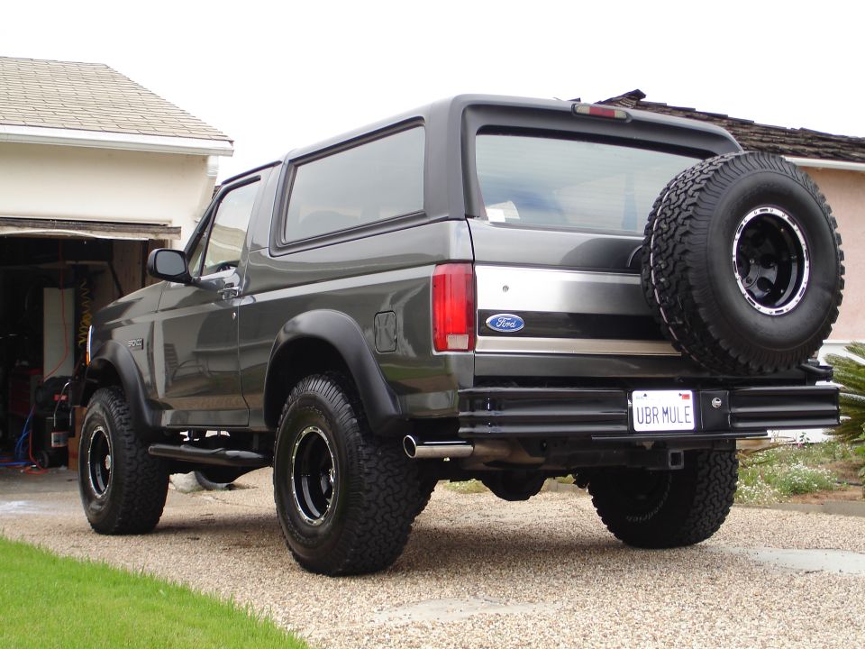Gray Ford Bronco parked in driveway, spare tire on back. License plate says UBR MULE