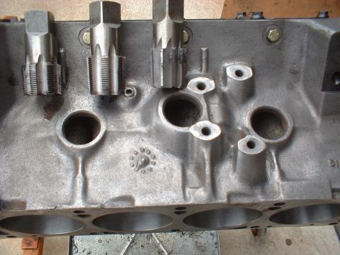 1957 Ford Custom Sedan - Close-up view of an engine block showing three taps inserted into threaded bolt holes.
