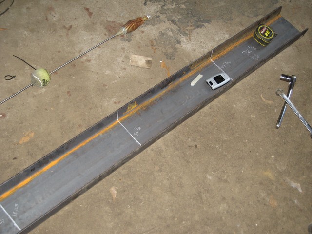 Steel beam with tape measure, wrench, and a tennis ball on a metal rod