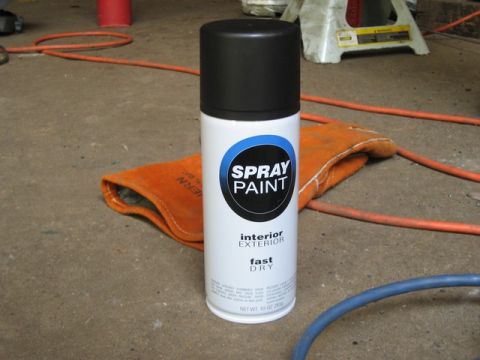 1995 Ford Bronco - A can of spray paint sits on a concrete floor next to an orange glove and orange and blue hoses.