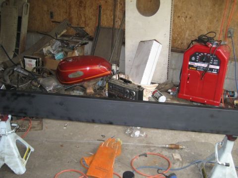 1995 Ford Bronco - A red motorcycle gas tank sits among various garage items, including a welder and tools.