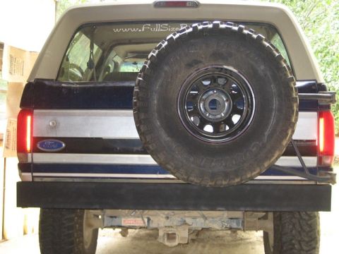 1995 Ford Bronco - The rear of a Ford Bronco shows its spare tire and a black bumper. A website address is visible on the rear window.