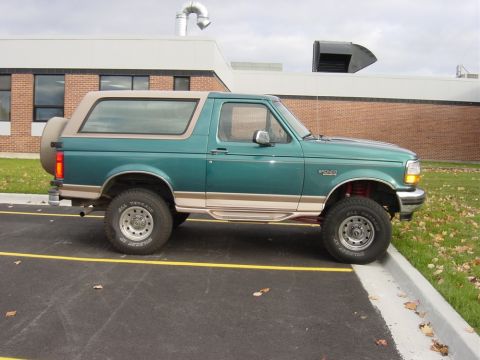 1996 Ford Bronco - This 1996 Ford Bronco is seen from the side, its distinctive green paint with tan trim and a spare tire mounted on the back.