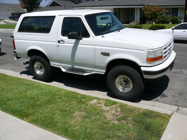 White two-door Ford Bronco SUV, 3/4 front passenger side, polished wheels and all-terrain tires