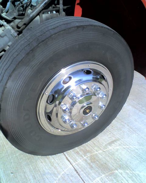 1989 International School Bus - A close-up view of a flat tire on a large vehicle, revealing chrome hubcaps and the Goodyear brand name.