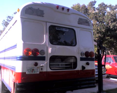 1989 International School Bus - School bus rear view with emergency door and taillights; a red pickup truck is partially visible.