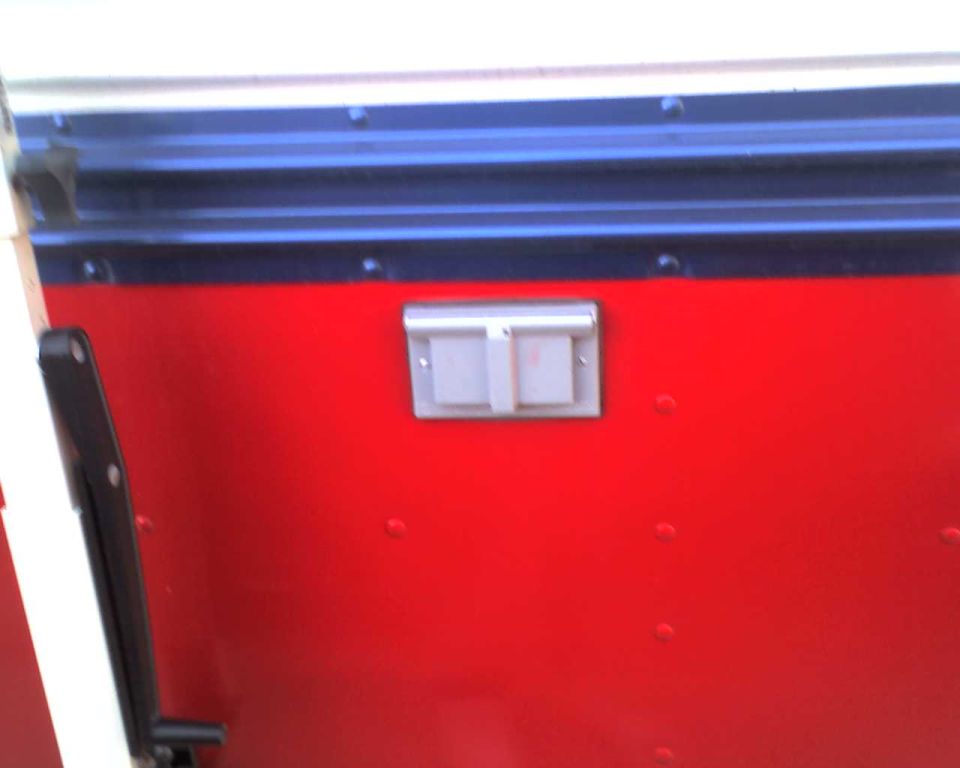 Red bus exterior with blue stripe and silver latch