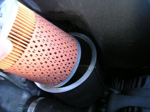 2002 BMW M3 - Close-up of an oil filter removal process, highlighting the filter's construction and housing.
