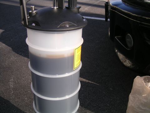 2002 BMW M3 - Used oil collected in a drain pan, with a portion of a black vehicle visible in the background.