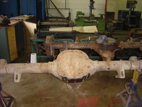 1996 Ford Bronco - Two rear axle assemblies are shown in a workshop setting, resting on jack stands.
