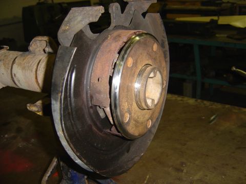 1996 Ford Bronco - Close-up of a vehicle's rear axle brake assembly, highlighting the rotor and drum brake mechanism.