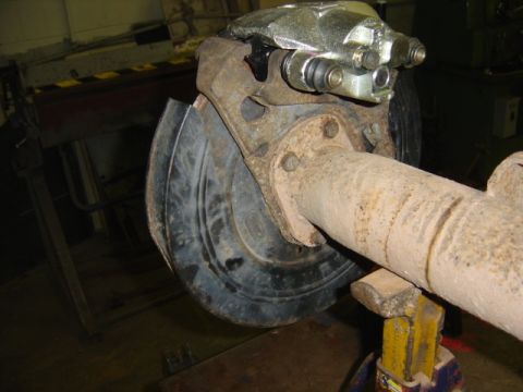 1996 Ford Bronco - Close-up of a vehicle's rear axle assembly, showing a brake caliper and rotor.