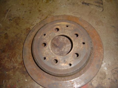 1996 Ford Bronco - A close-up view of a rusty brake rotor, showing signs of wear and age.