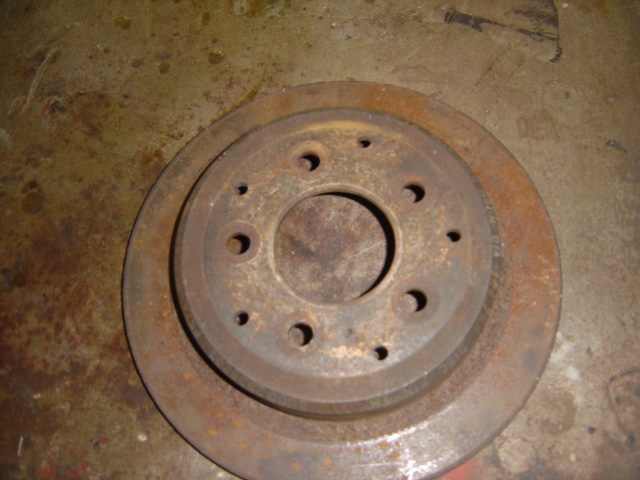 Rusty brake rotor on a concrete floor